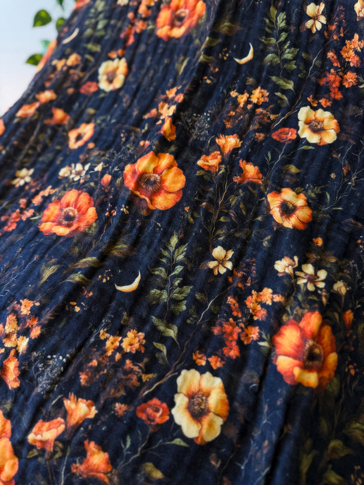 Floral patterned fabric with orange and yellow flowers on a dark blue background